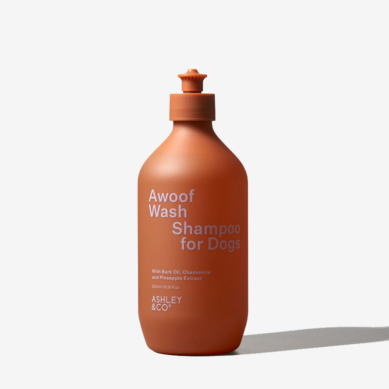 A rusty Orange bottle of "Awoof Wash Shampoo for Dogs" against a white background. by ASHLEY & CO.