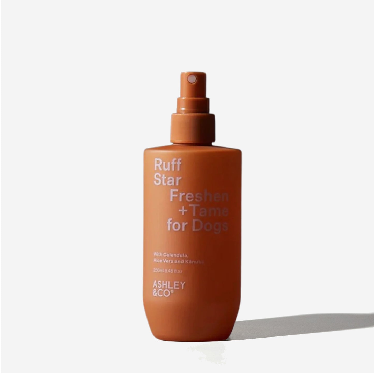 A rusty orange spray bottle labeled "Ruff Star Freshen + Tame for Dogs" by ASHLEY & CO.