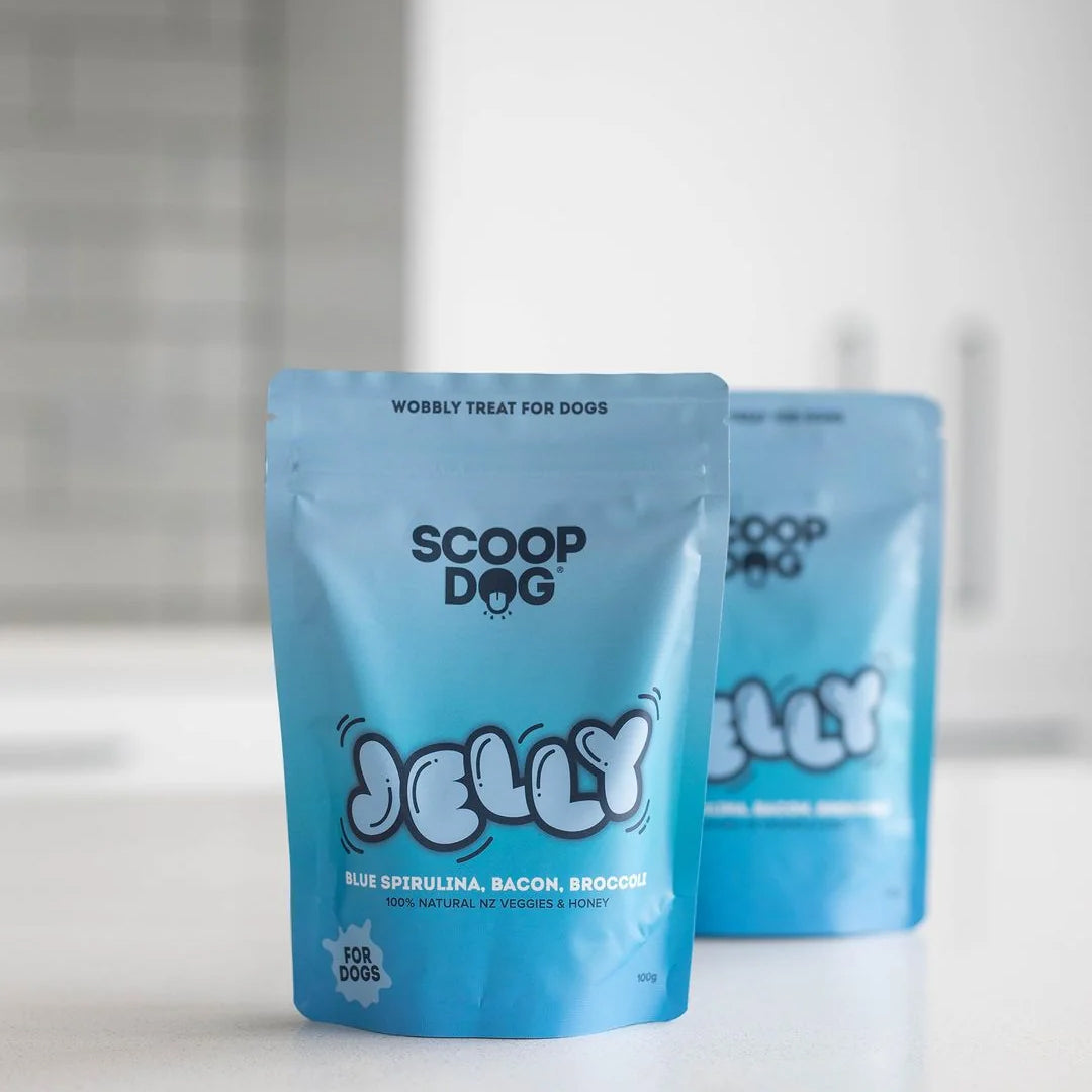 Two blue dog treat packages labeled "SCOOP DOG JELLY" on a kitchen counter.