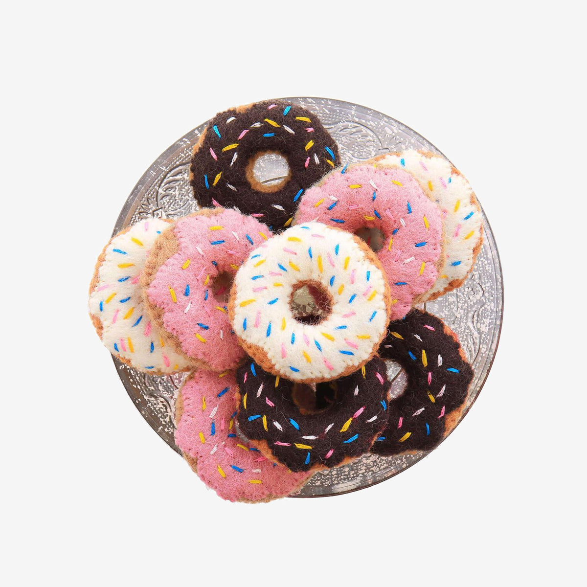 Plate of pink and chocolate frosted doughnuts with sprinkles on white background.