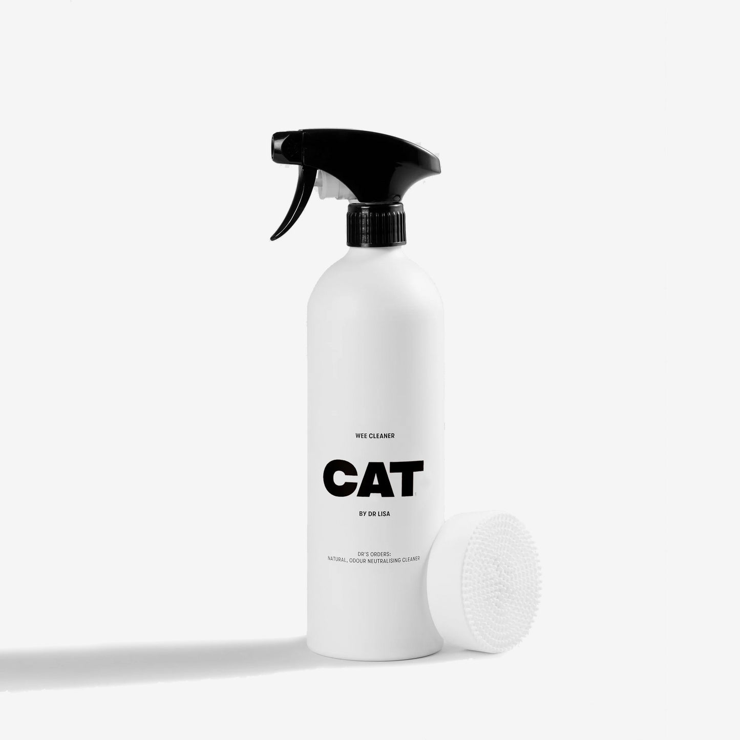 A white spray bottle labeled "CAT WEE CLEANER BY ID LISA" with a black spray nozzle, cap detached, on a white surface.