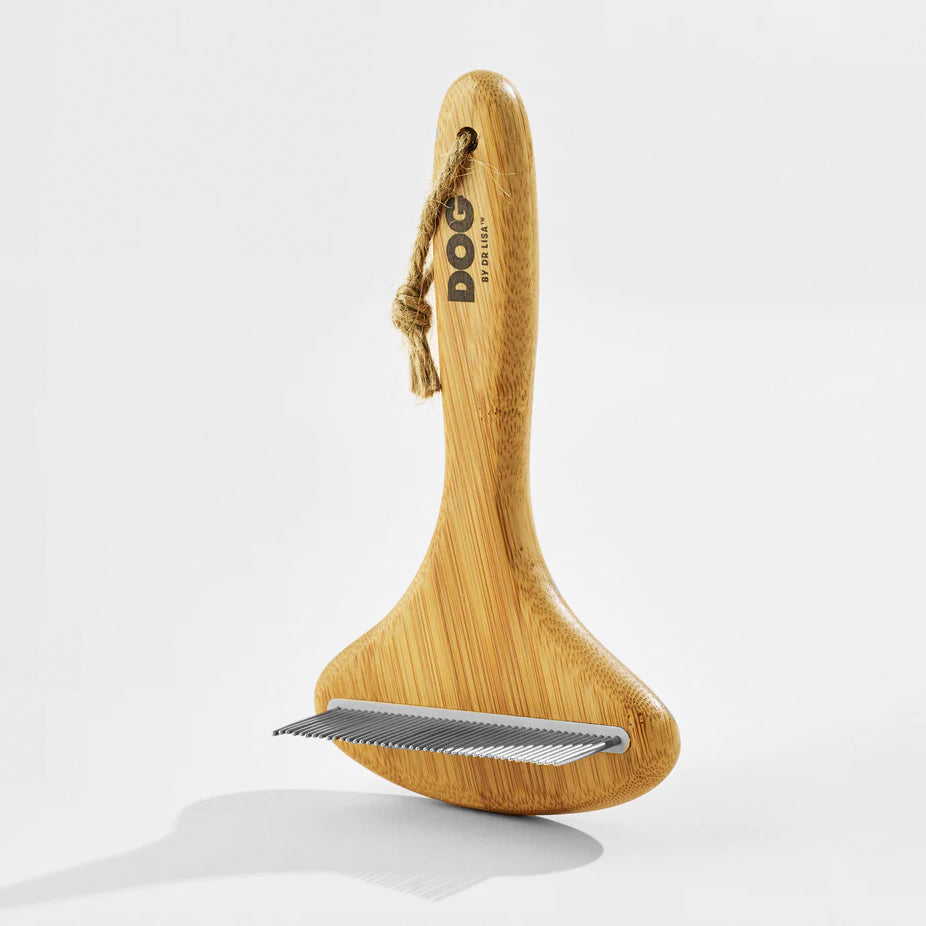 Bamboo dog grooming tool with a metal comb edge and a looped string handle for easy storage. Perfect for pet care.