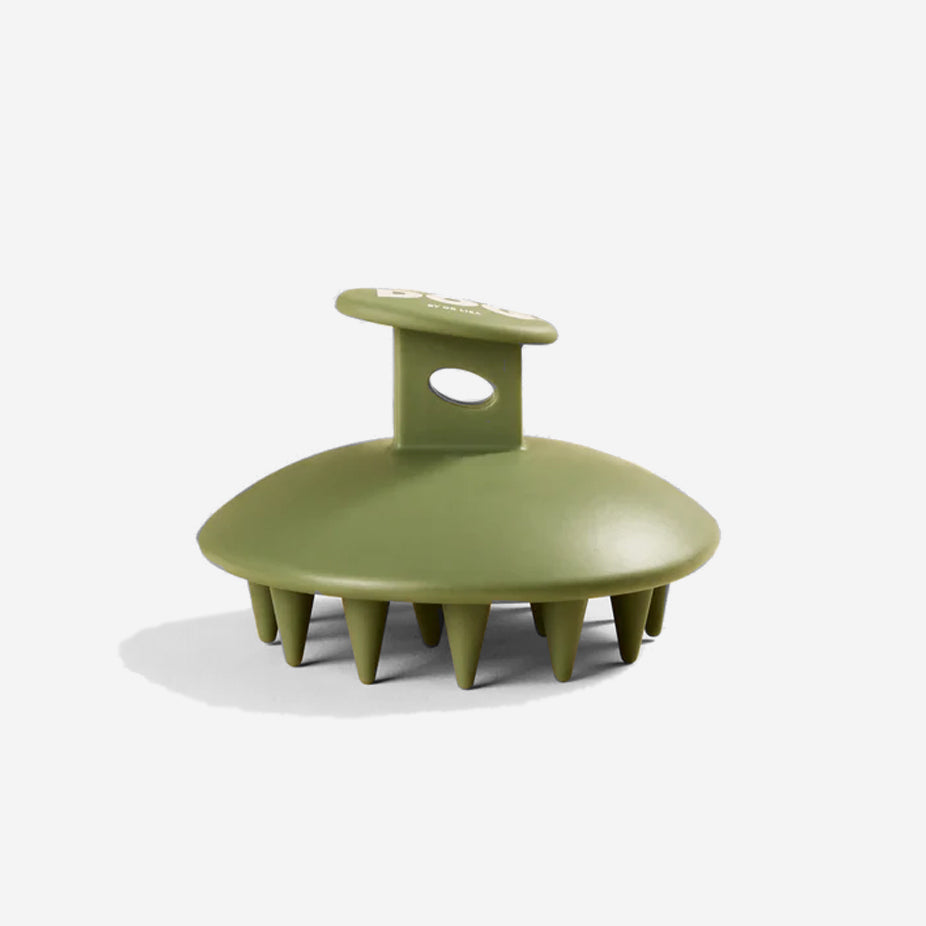 Olive green silicone dog brush with "DOG by DR Lisa" logo, on a light background.