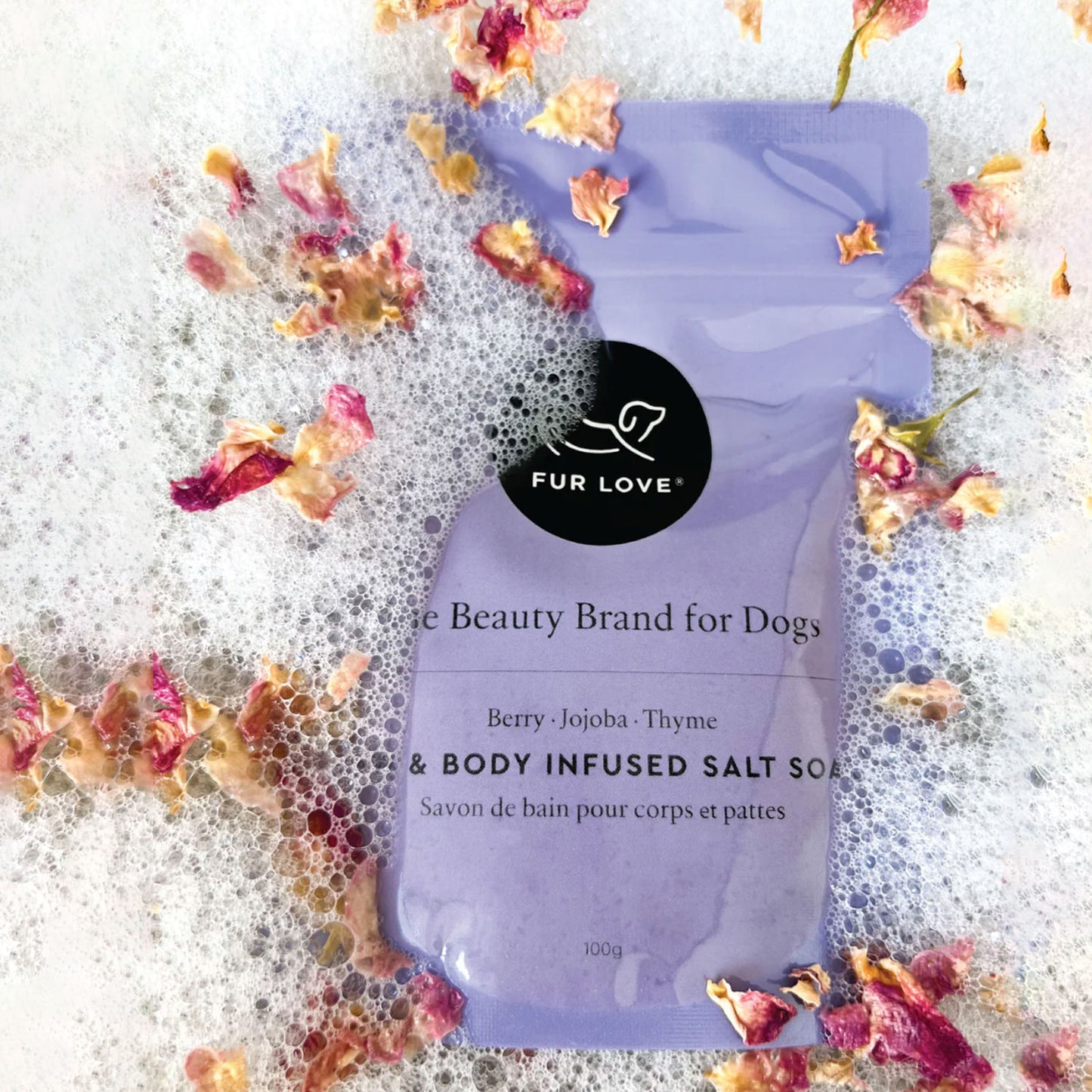 Dog beauty brand soap with dried flowers and bubbles on a textured background.