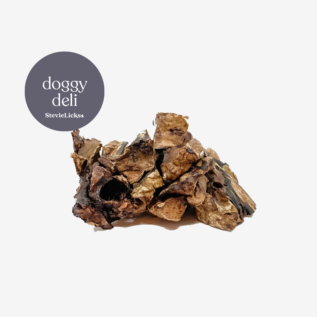 A pile of natural dog treats in various dark brown and beige shades, labeled "doggy deli" by StevieLicks.