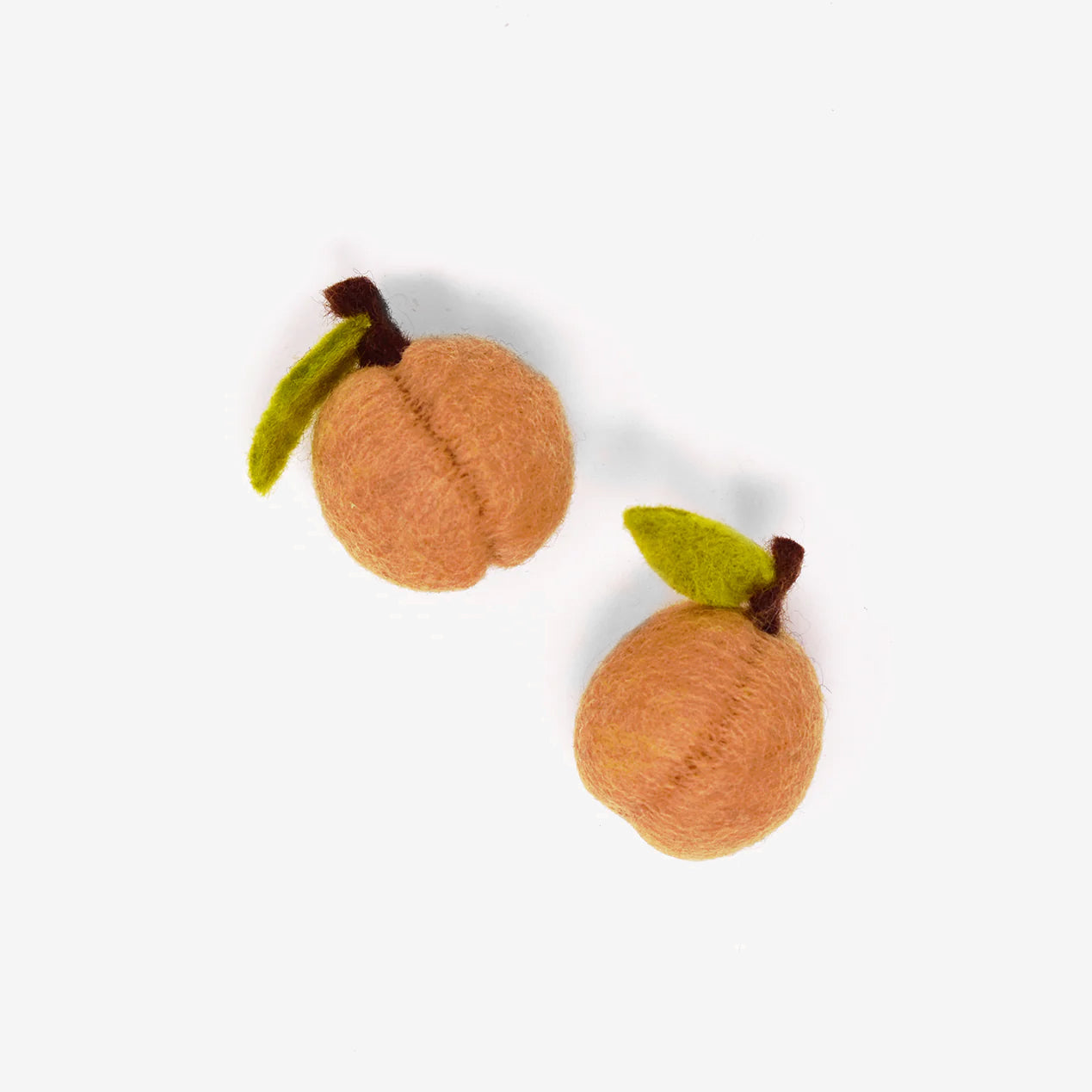 Two felt crafted peaches on a white background.