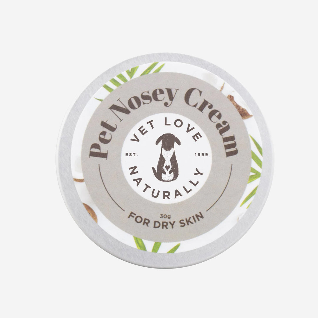 Label of Pet Nosey Cream, promoting natural care for dogs with dry skin, featuring a logo of a dog, surrounded by green leaves.