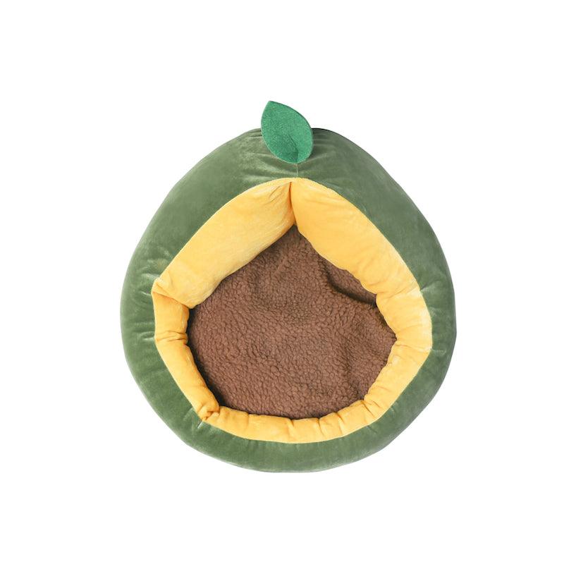 A plush avocado-shaped pet bed with a green outer layer, yellow inner layer, a brown round cushion inside, and a small green leaf on top.