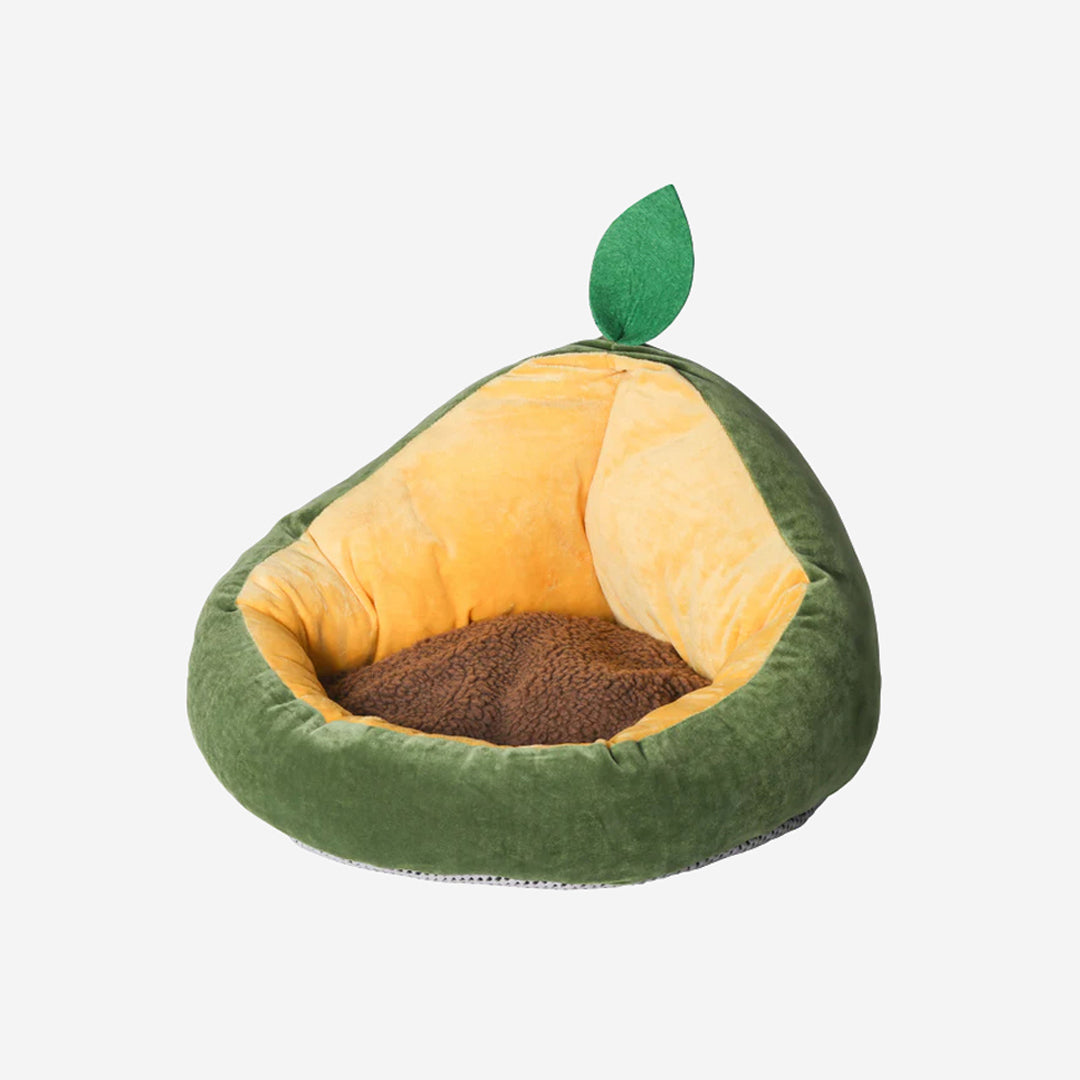 A plush avocado-shaped pet bed with a green base and a brown center and a leaf at the top.