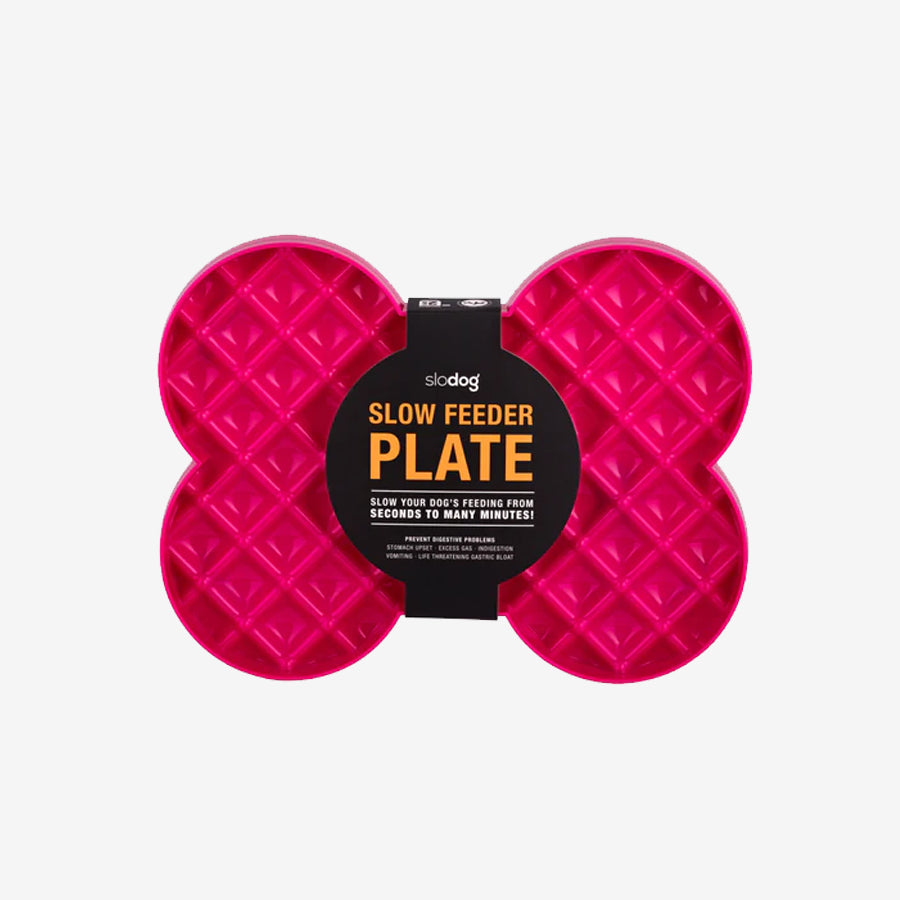 Pink slow feeder plate for dogs in a bone shape with a textured surface, promoting slower eating to prevent digestive issues.