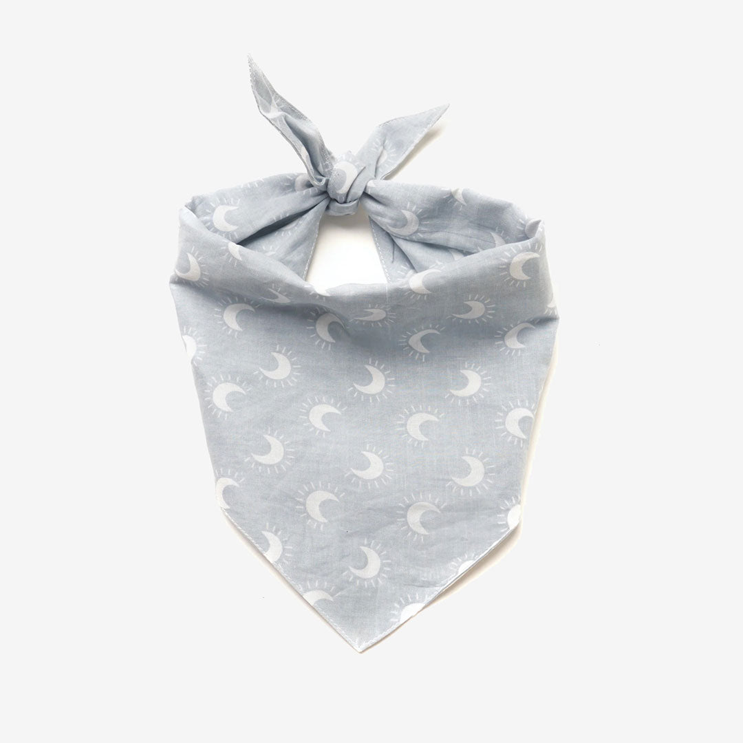 Light blue bandana with a crescent moon and sun pattern, tied neatly at the top, set against a plain white background.