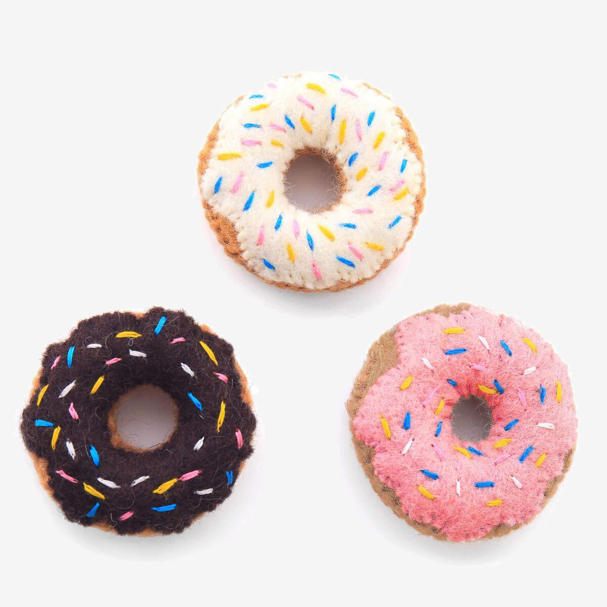 Three colourful felt donuts with sprinkles on a white background.