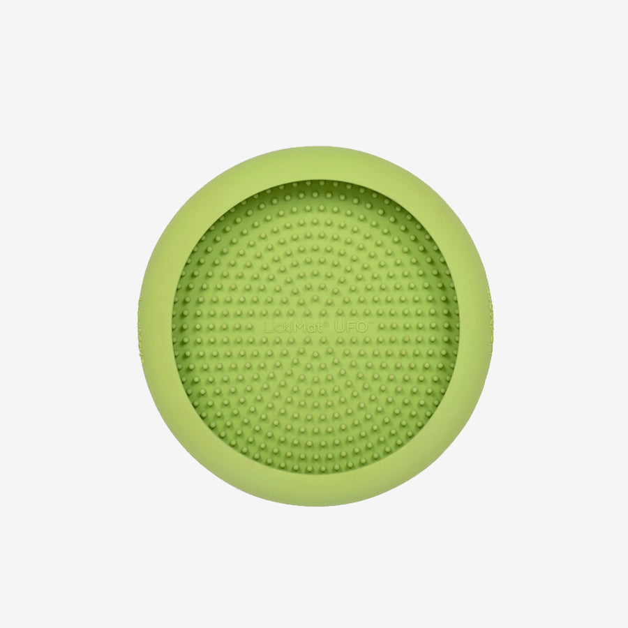 Circular green silicone pet mat with textured surface and raised dots, designed for feeding or treating pets.