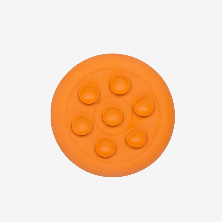Top view of a round, orange silicone suction plate featuring six raised circular sections for separating food.