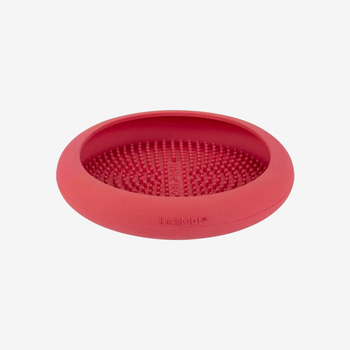 A red silicone LickiMat with a textured surface, designed for pets to lick and enjoy treats, promoting engagement and slow feeding.