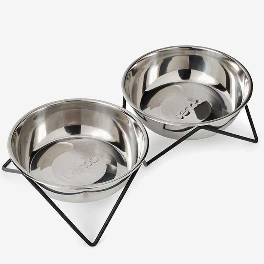 Two stainless steel pet bowls in a black metal stand.