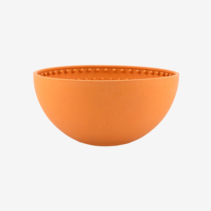 A round, orange silicone pet bowl featuring a dotted interior for enhanced grip and designed by Lickimat.