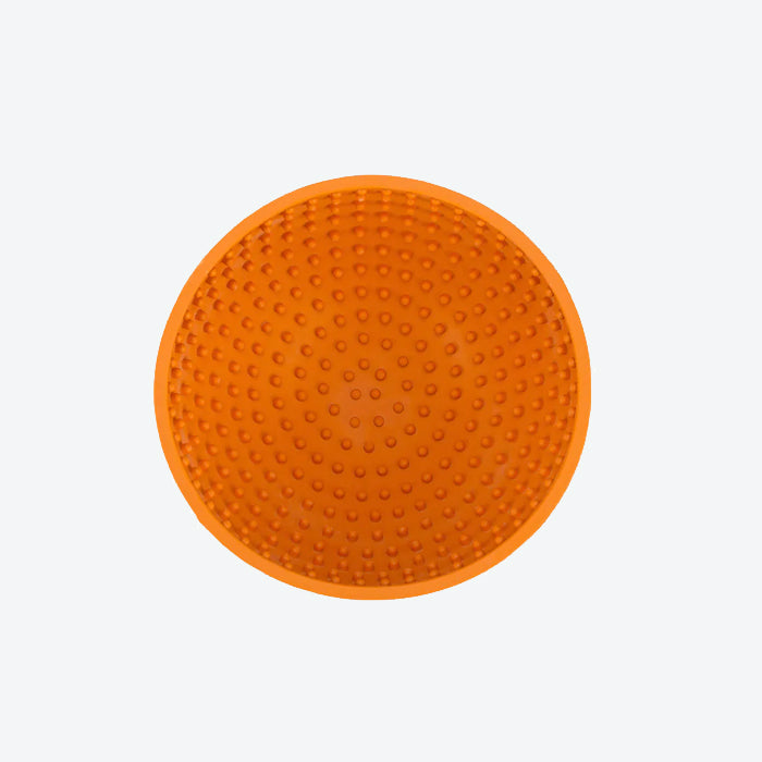 Circular orange silicone mat with textured surface featuring raised dots, designed for grip and traction.
