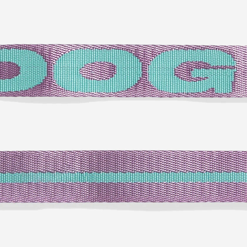Two strips of fabric, top with "DOG" text, bottom with a teal line on purple.