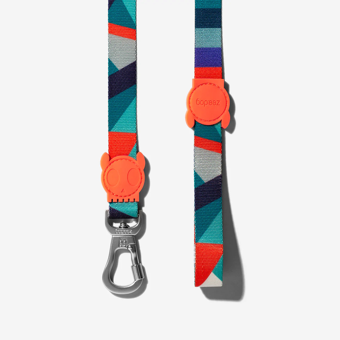 Colourful pet leash featuring a geometric design with an orange paw print attachment, showcasing modern style and functionality.