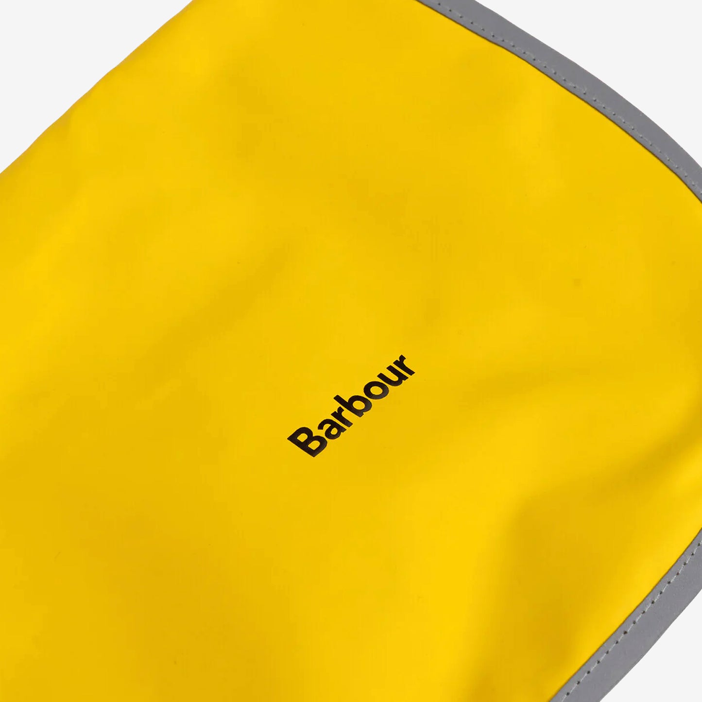 Close-up of a vibrant yellow Barbour bag, featuring a sleek grey reflective trim and bold black logo on the surface.