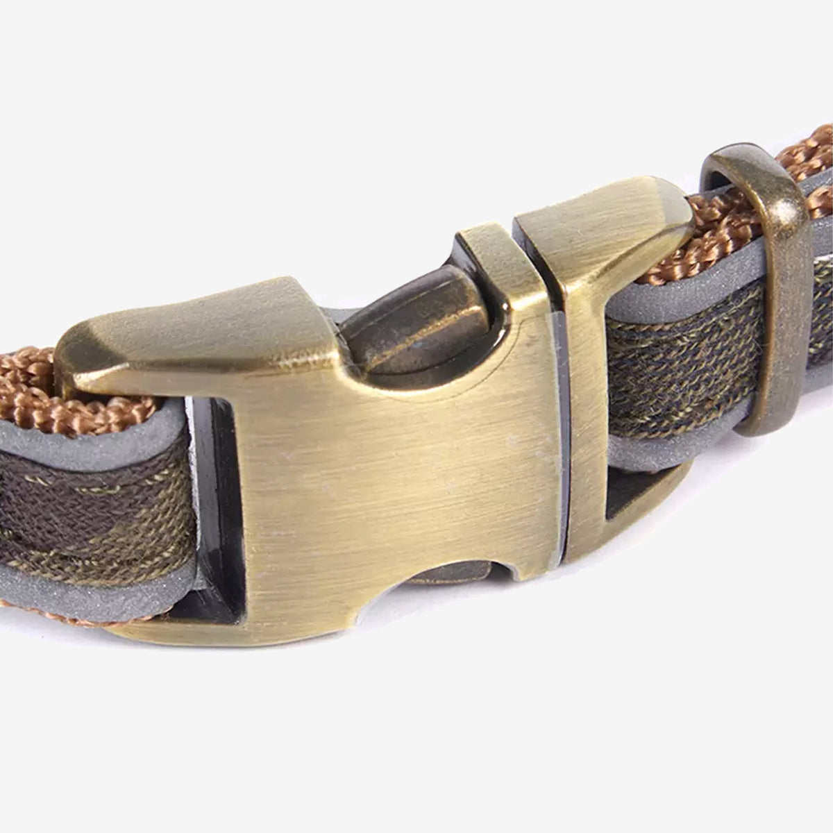 Close-up of a sturdy, bronze-coloured buckle on a woven strap, showcasing intricate texture and design elements.