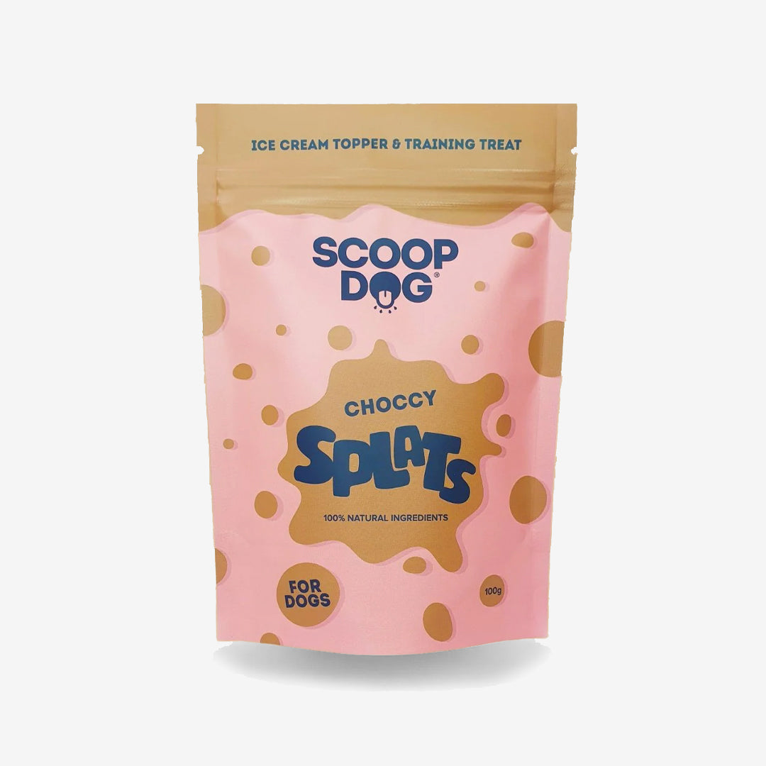 A pink package of "Scoop Dog Choccy Splats" dog treats with polka dots and text indicating natural ingredients.