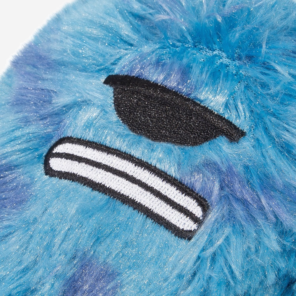 Close-up of a blue furry textured dog toy with black and white pirate eye patch aplique.