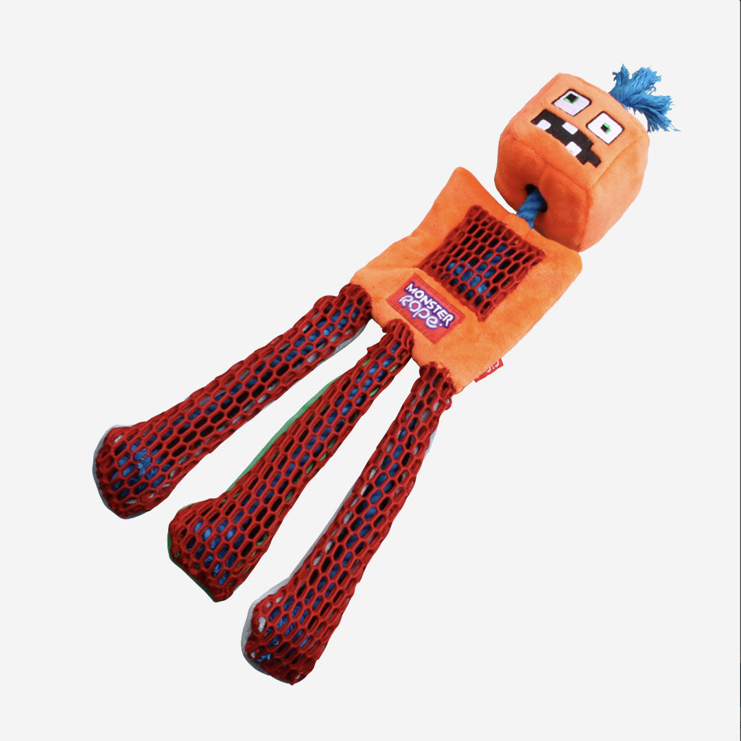 A plush orange monster dog toy with mesh legs and a tuft of blue hair.