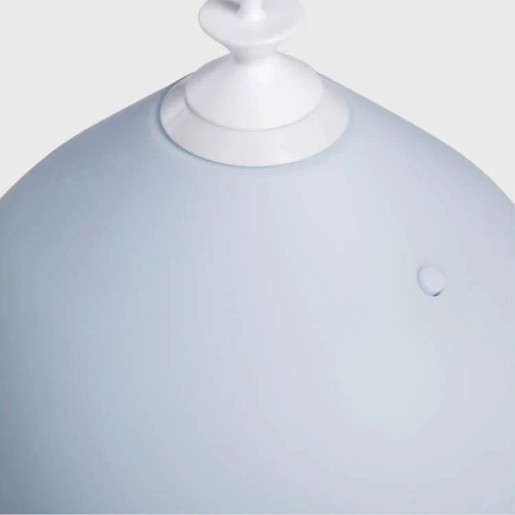Close-up of a pale blue spherical object with a white nozzle.