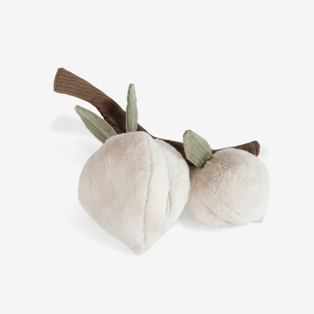 Soft plush cotton plant with two cotton bolls and green leaves, resting on a textured brown stem against a white background.
