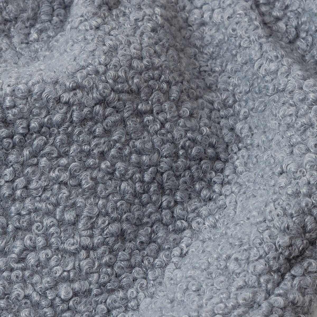 Close-up of a textured grey fabric with a curly pile design.