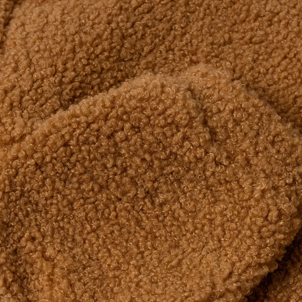 Close-up of a textured brown fabric with a curly pile design.
