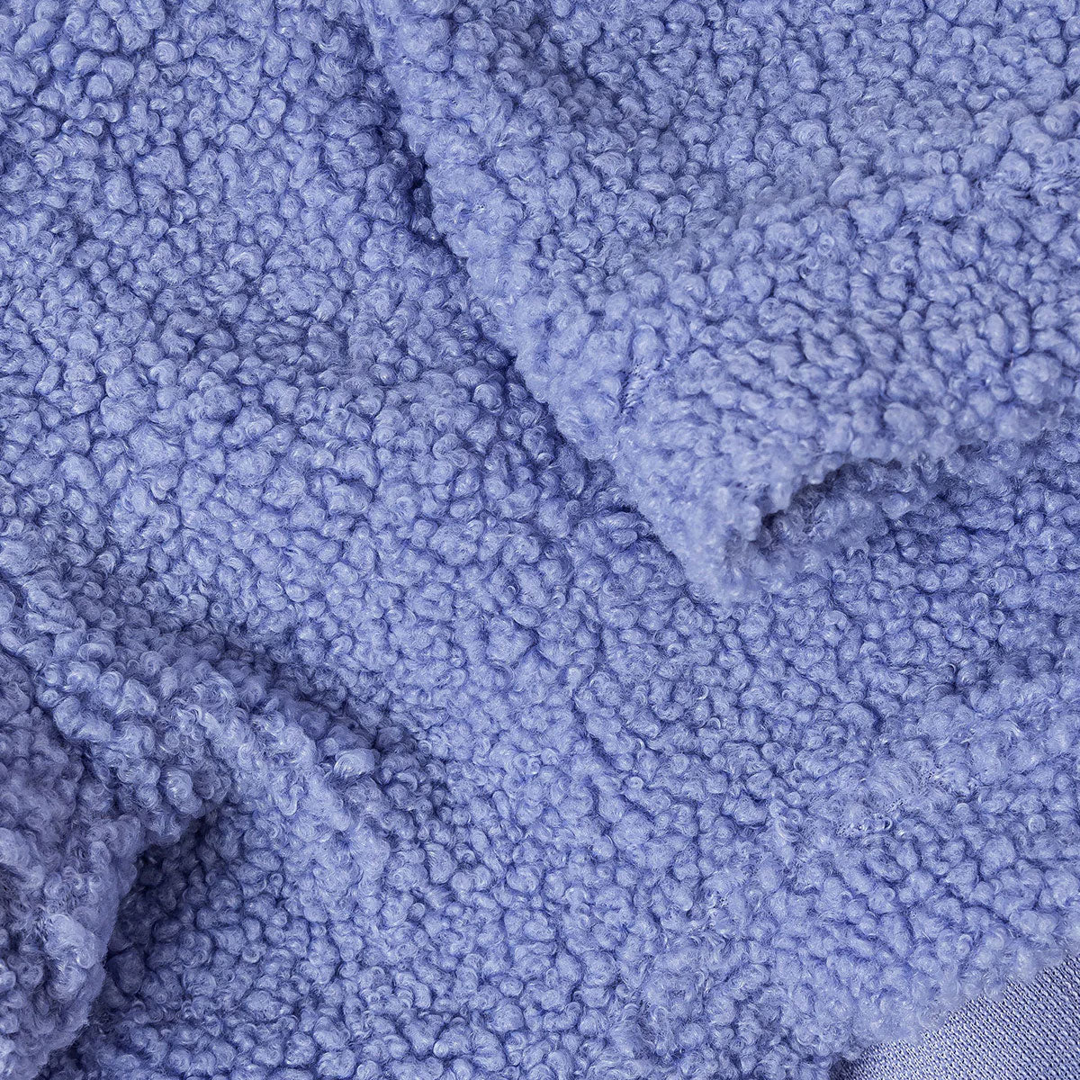 Close-up of a textured periwinkle coloured fabric with a curly pile design.