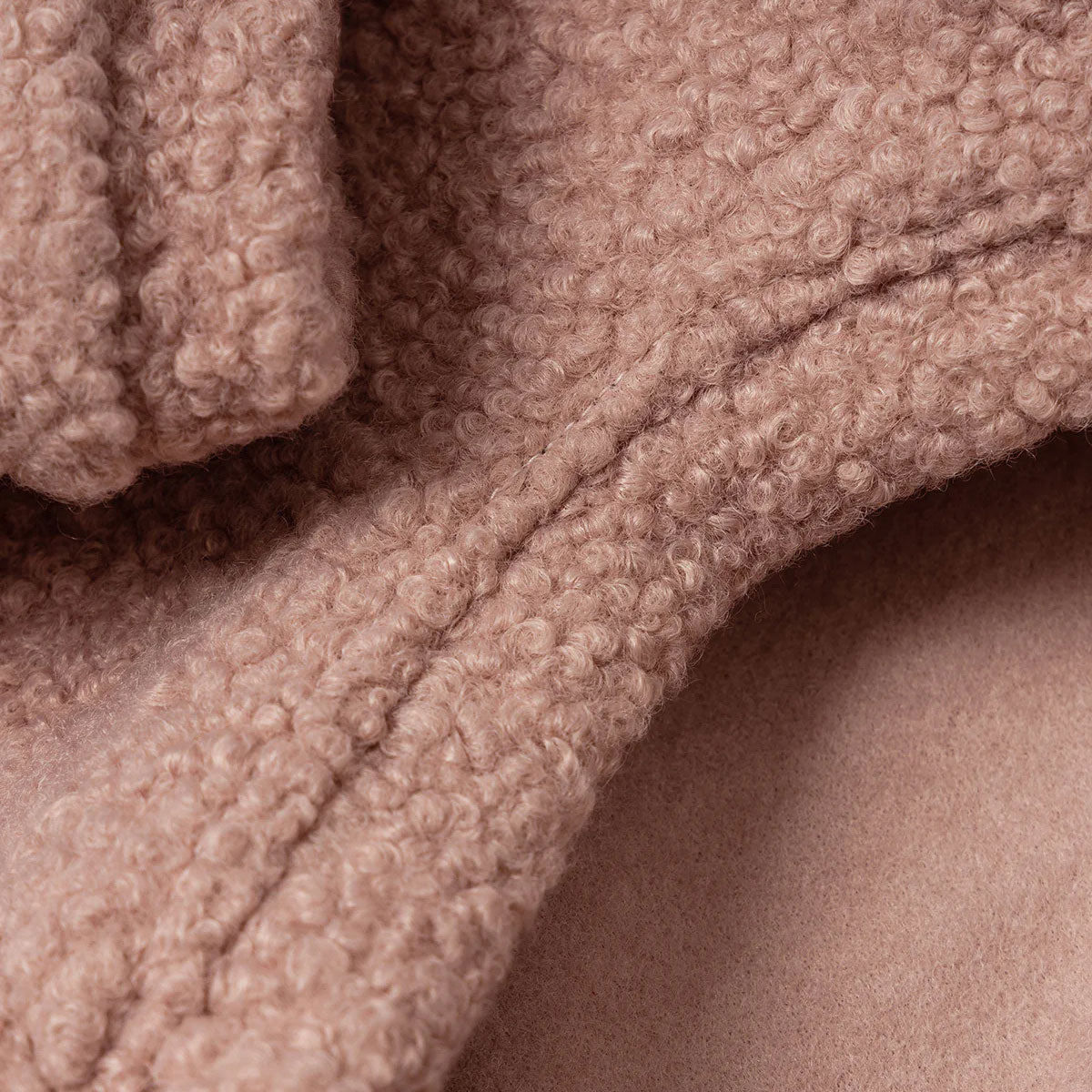 Close-up of a textured blush fabric with a curly pile design.