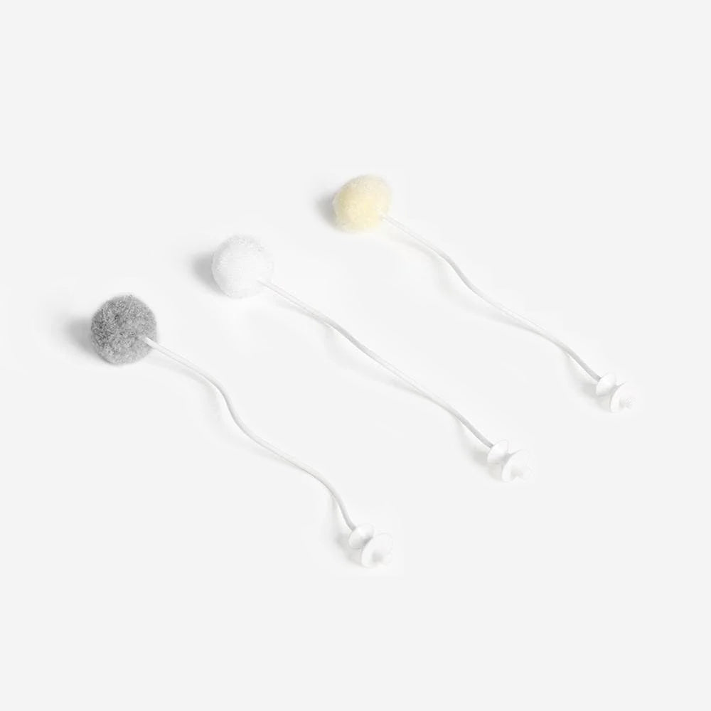 Three fluffy pom-poms with white wiggly stems on a white background.