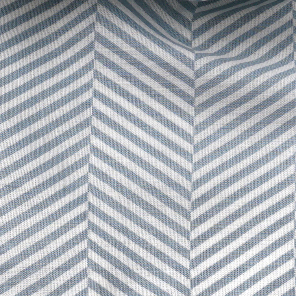 Textured fabric with diagonal blue and white stripes forming a herringbone pattern.