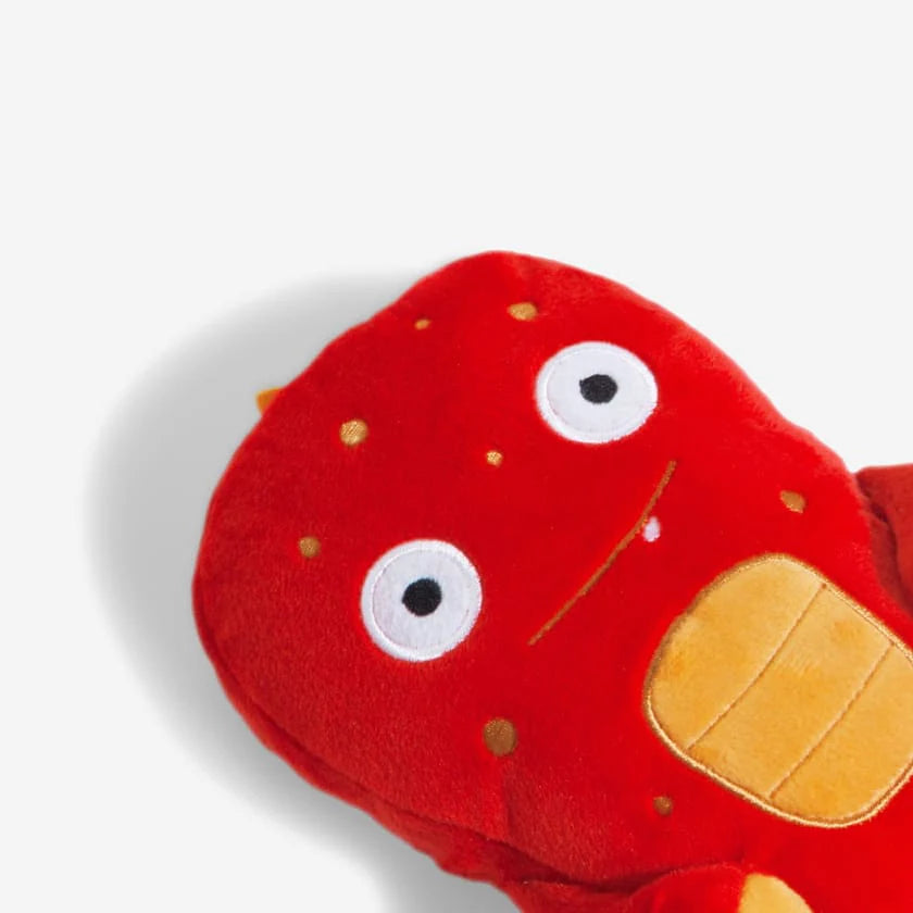 Red plush alien toy with cute eyes and a orange chest and spots on a white background.
