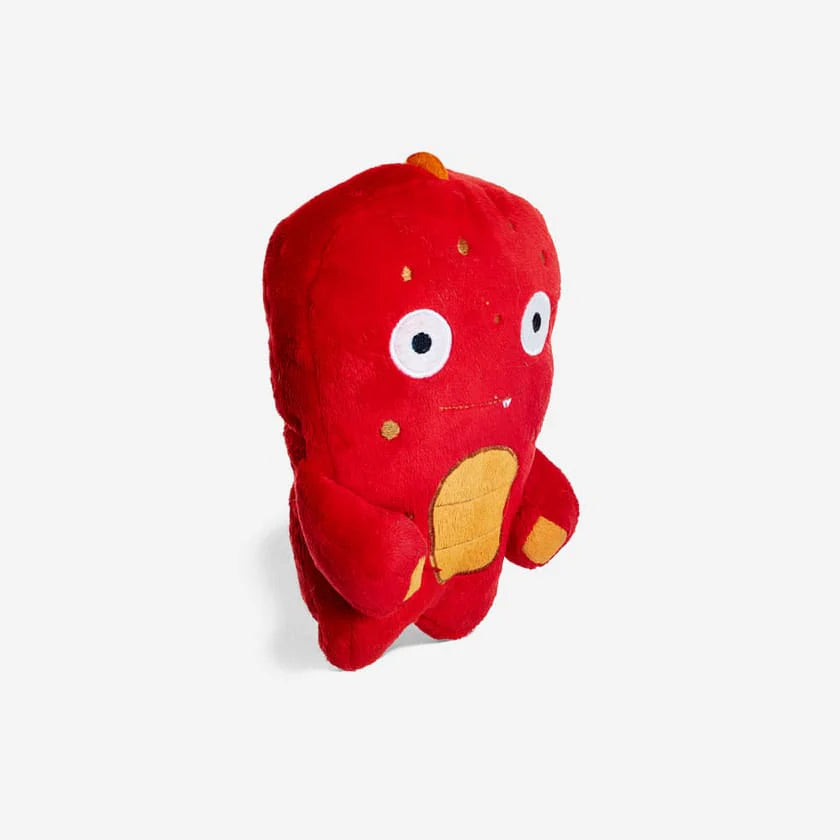 Red plush alien toy with cute eyes and a orange chest and spots on a white background.