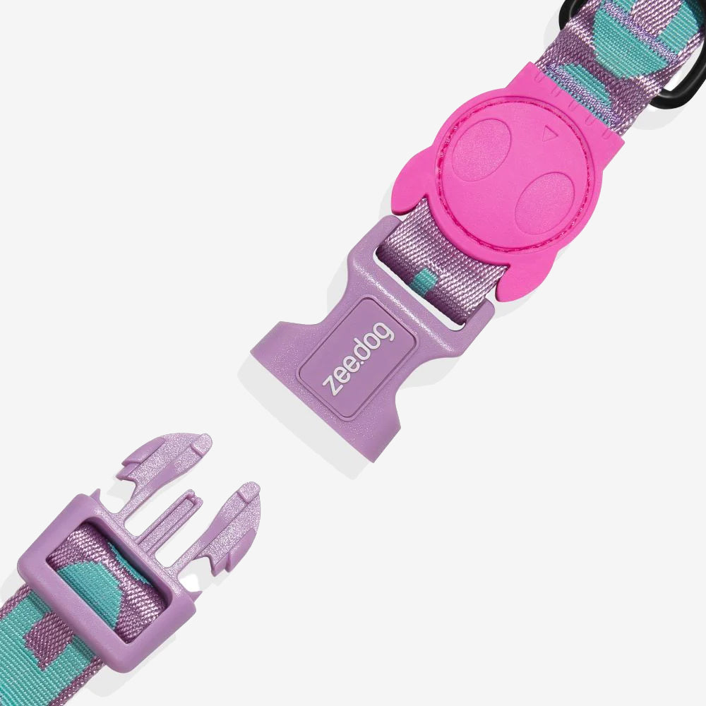 Colourful pet harness clip featuring a purple and pink design with a playful logo, showcasing a durable and stylish buckle system.