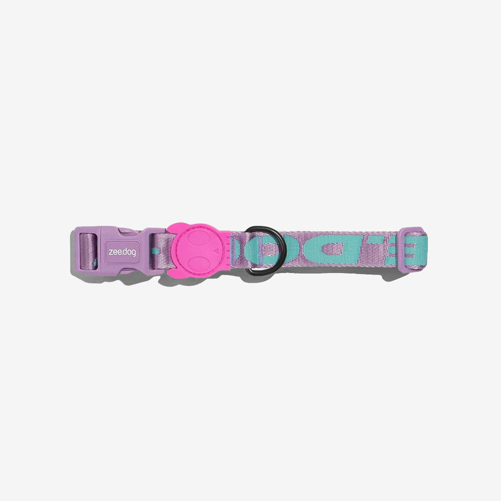 Colourful dog collar in purple and teal with a cute pink buckle featuring a smiley face and the brand name "zee.dog."