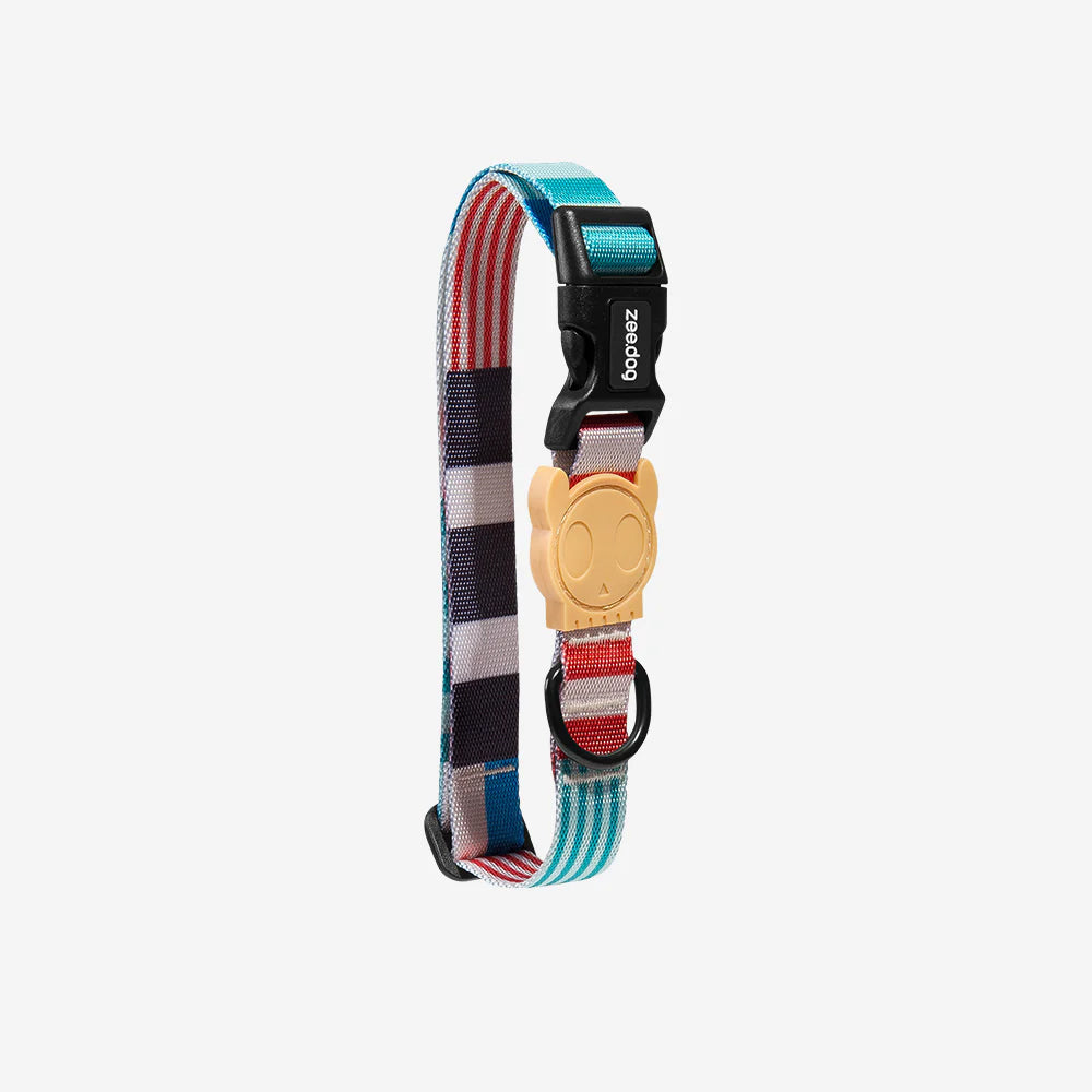Colourful adjustable dog collar with a playful skull-shaped buckle, featuring a mix of patterns in blue, red, and white stripes.