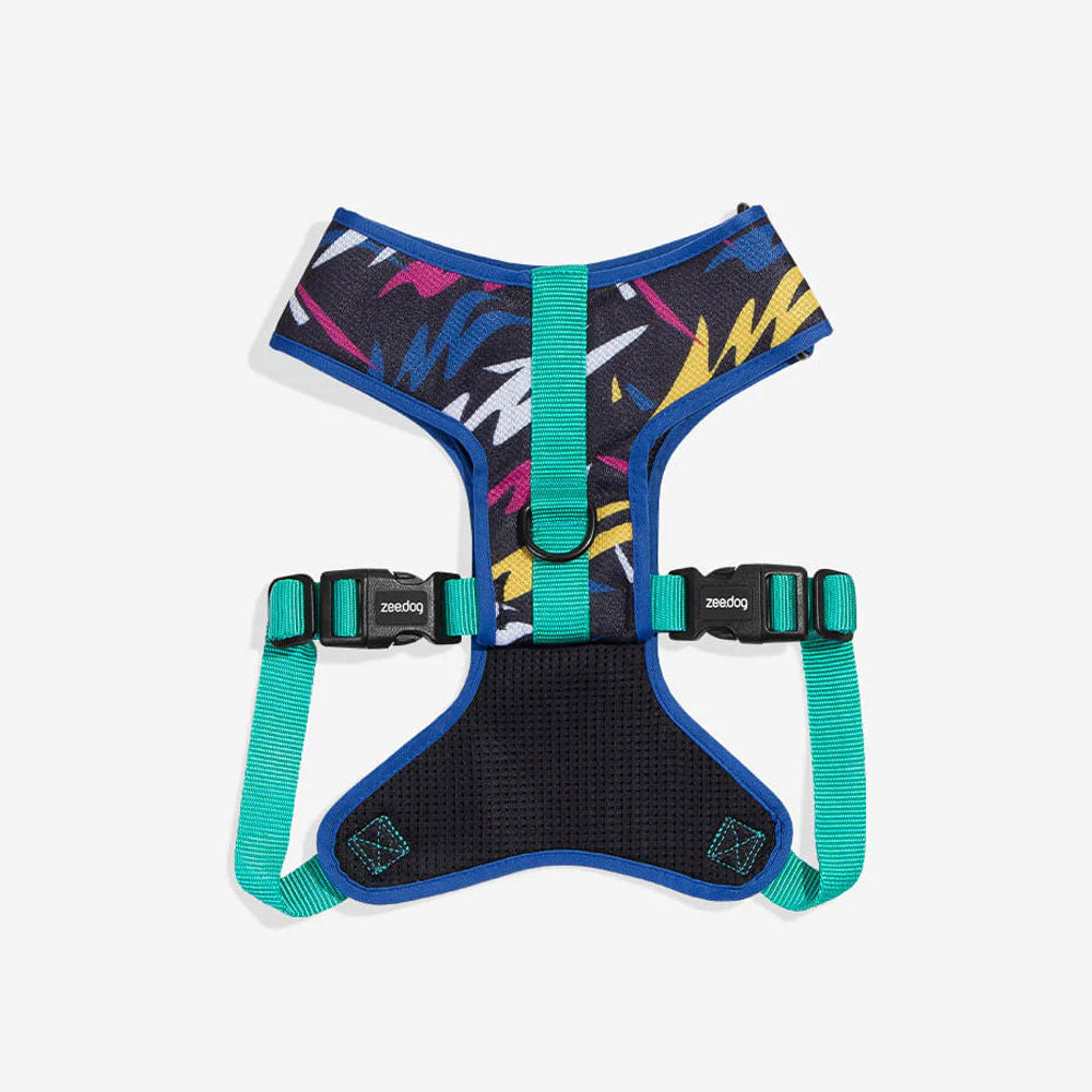 Colourful dog harness with a geometric design, featuring adjustable straps and padded mesh for comfort.