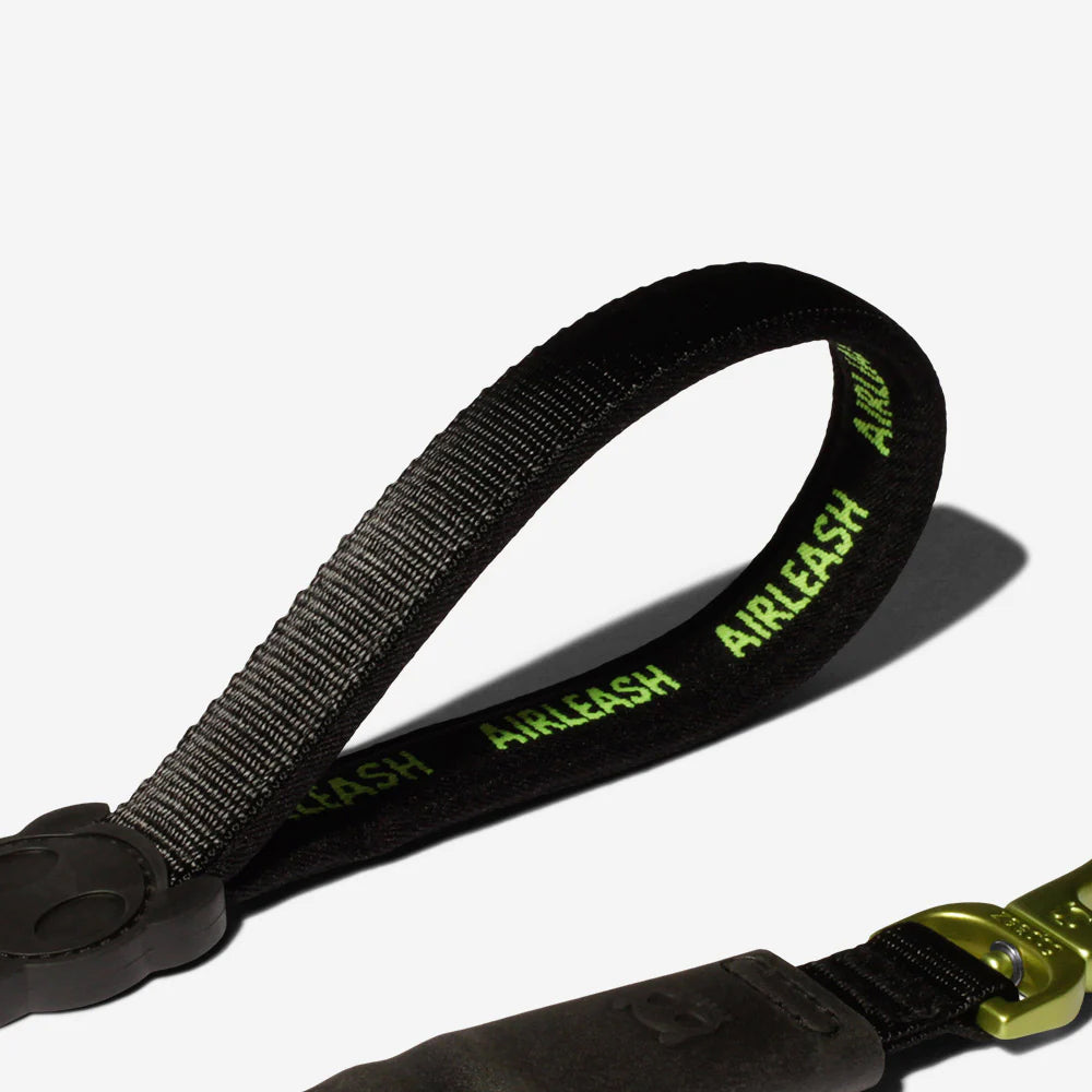 Black dog leash with green "AIRLEASH" text, plastic buckle, and metal clasp on a white background.