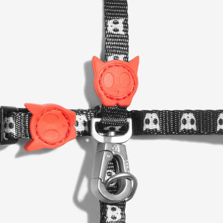 Black and white patterned pet harness with skull icons and red buckles, featuring a galvanised aluminium clasp.