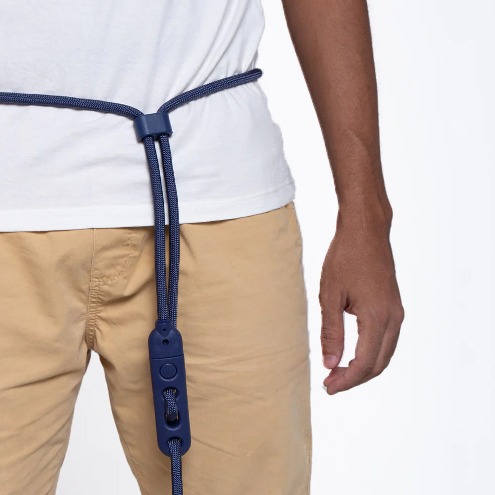 A close-up of a person's waist wearing a blue adjustable belt with a toggle, paired with a white t-shirt and tan pants.