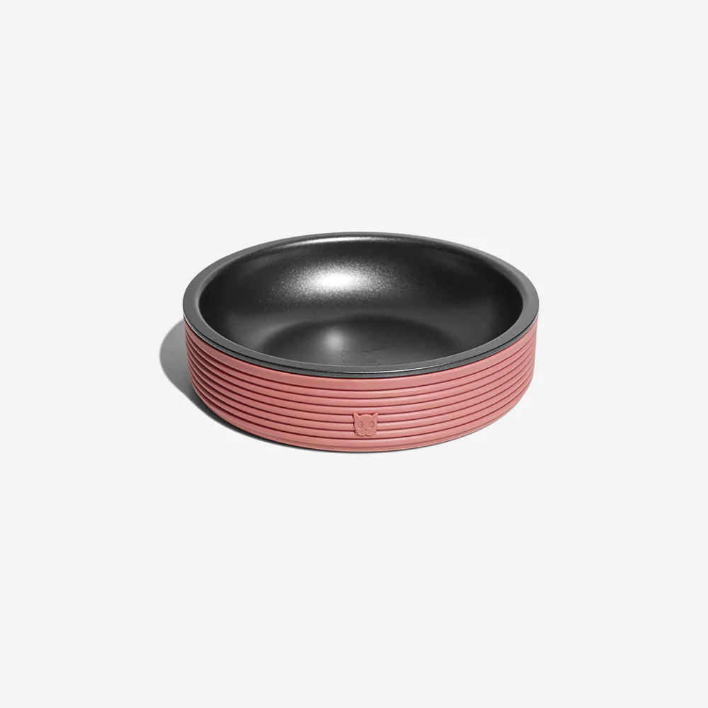 A stylish pet food bowl in pink and black, resting on a white background.