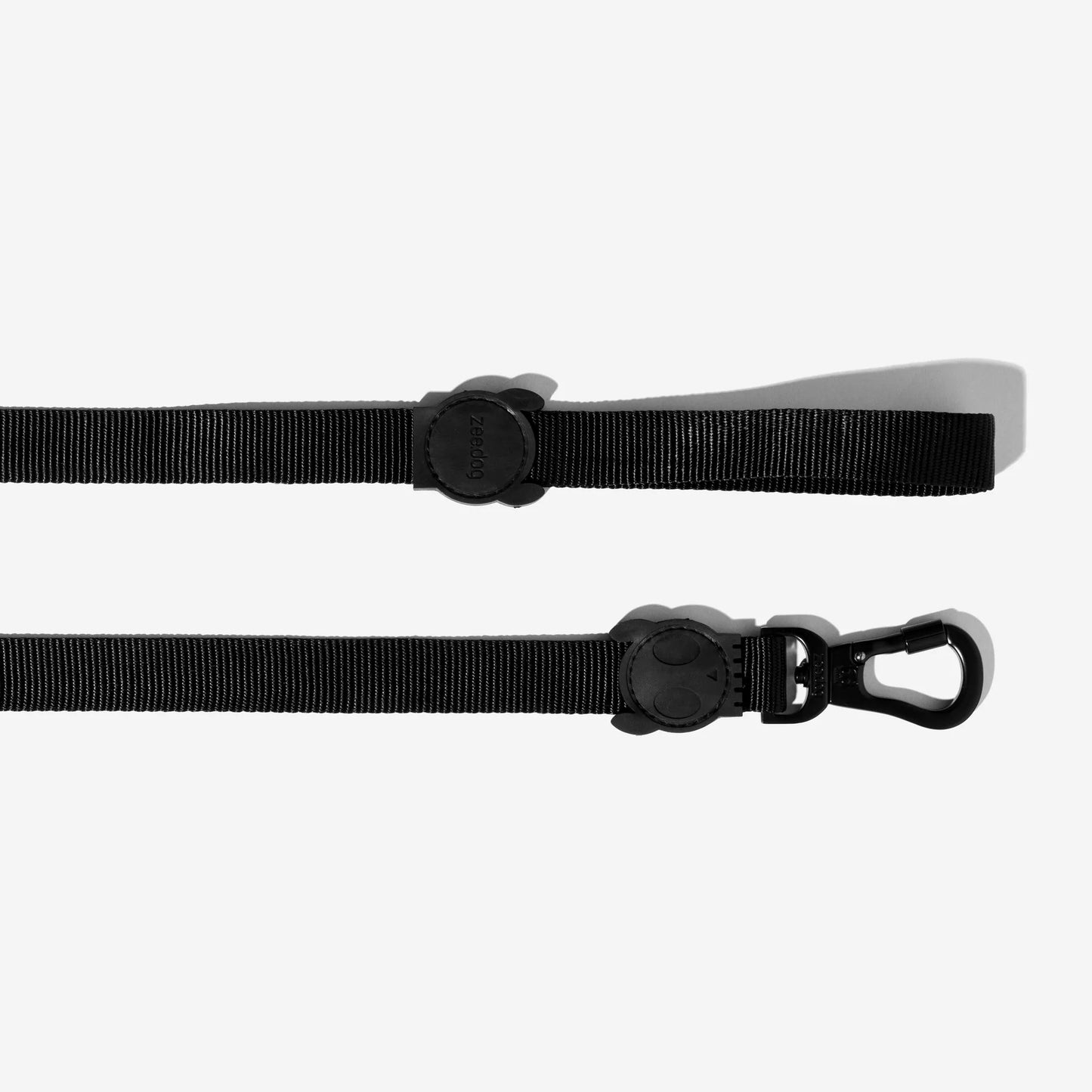 A black dog leash with a sturdy clip and branded rubber handle, resting on a white background.
