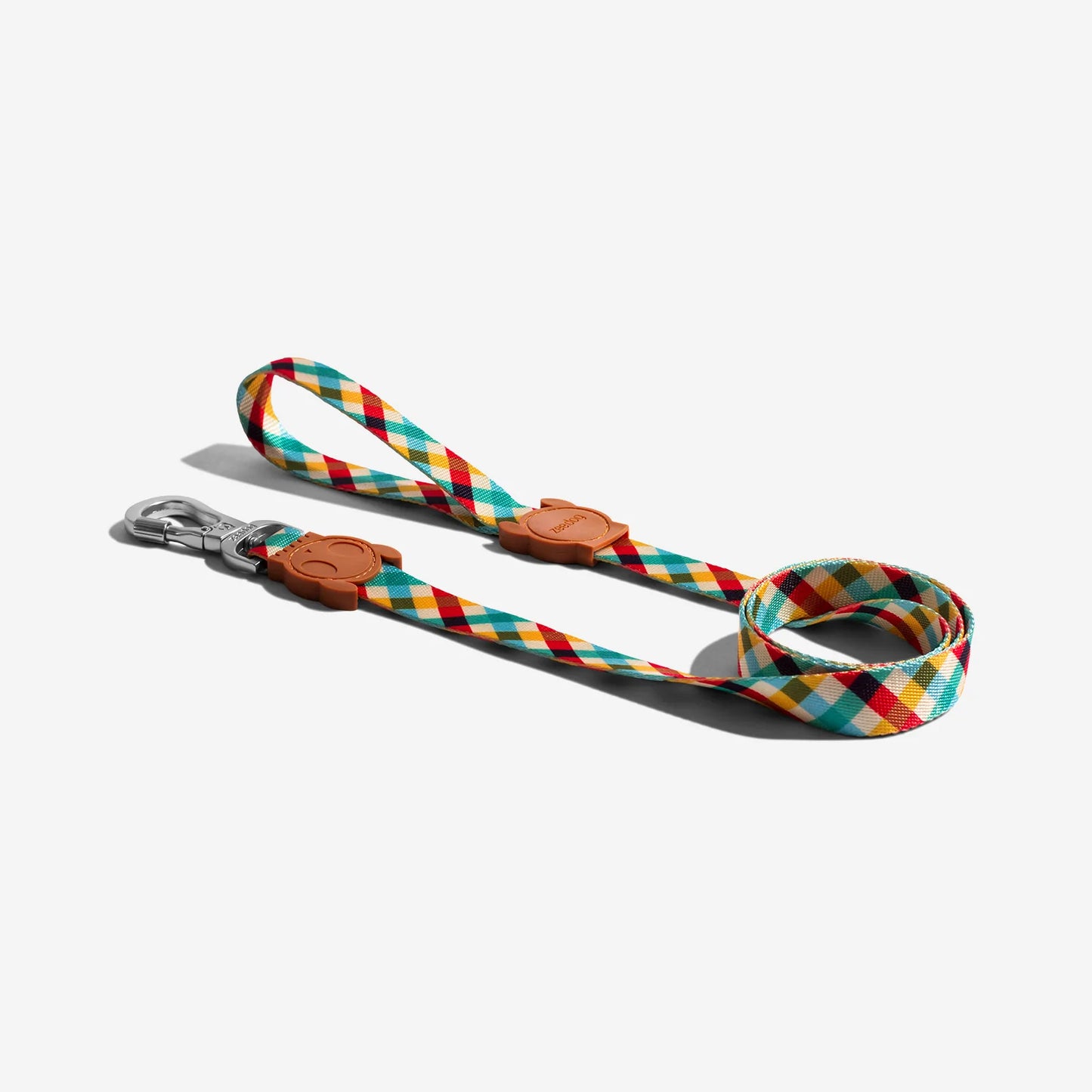 Colourful dog leash featuring a diamond pattern in red, yellow, teal, and cream, with a metal clip and rubber details.