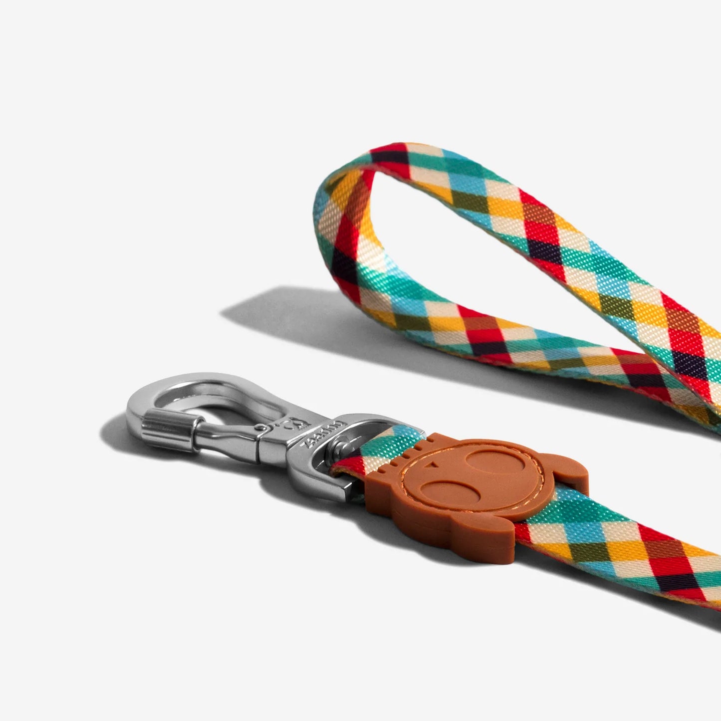 Colourful patterned dog leash with a bronze clip and a cute bear-shaped tag attachment.